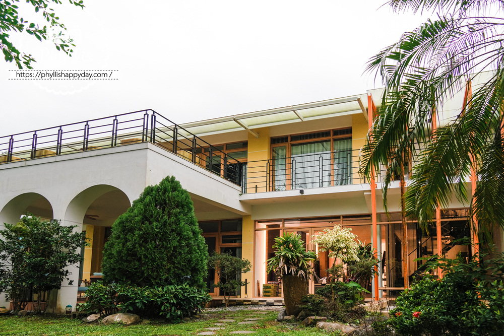 【湖畔莊園】冬山梅花湖旁的質感親子、寵物民宿|從大廳到早餐都充滿溫度,走路2分鐘就到湖邊的療癒旅程 - 第2張圖 宜蘭冬山湖畔莊園的白色外觀與庭院綠意,呈現安靜又放鬆的湖畔住宿氛圍