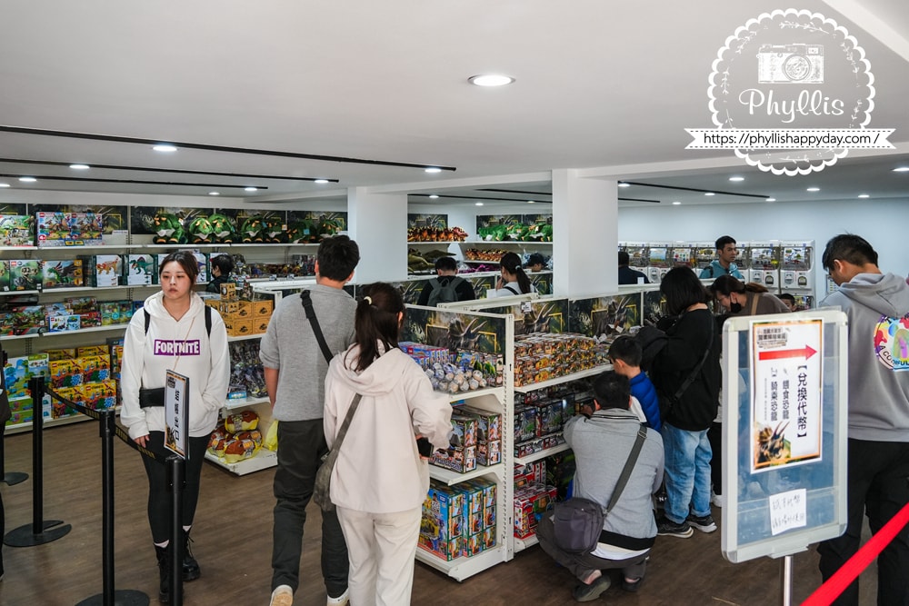 【恐龍大復活-關渡探險樂園】台北親子恐龍展實逛分享:70+會動大型恐龍超好拍,小朋友整場尖叫超喜歡 - 第30張圖 親子家庭在恐龍大復活關渡探險樂園紀念品店選購恐龍周邊