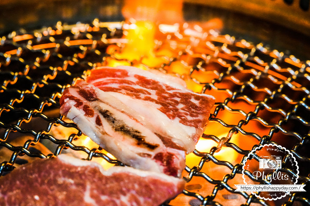 【京燒肉】烤肉過程中炭火冒起的畫面，呈現公益路燒肉餐廳現烤肉品的香氣與視覺效果